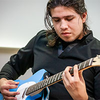 mcc student play guitar